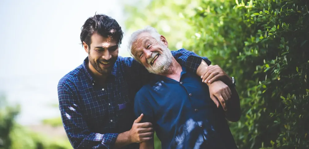 Father and son walking together down a green outdoor path